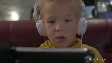 小男孩戴着白色耳机，用手机看视频或漫画